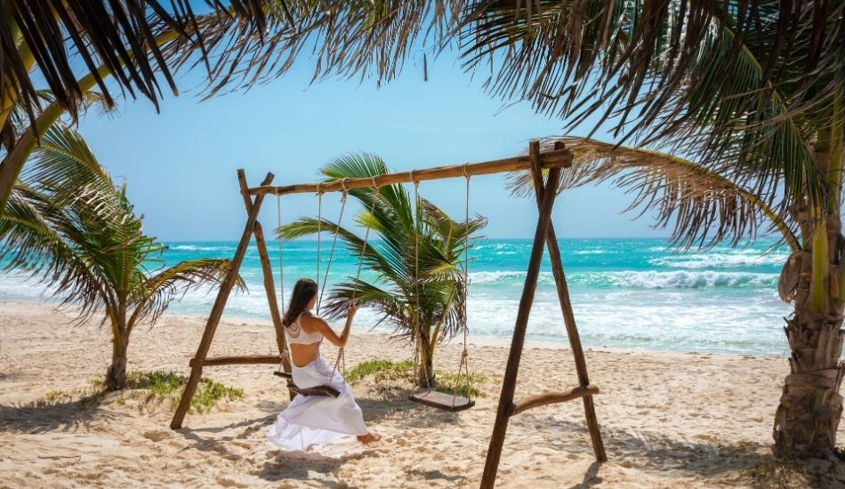 Best beaches for investment in Mexico โ Tulum beachfront swing under palm trees