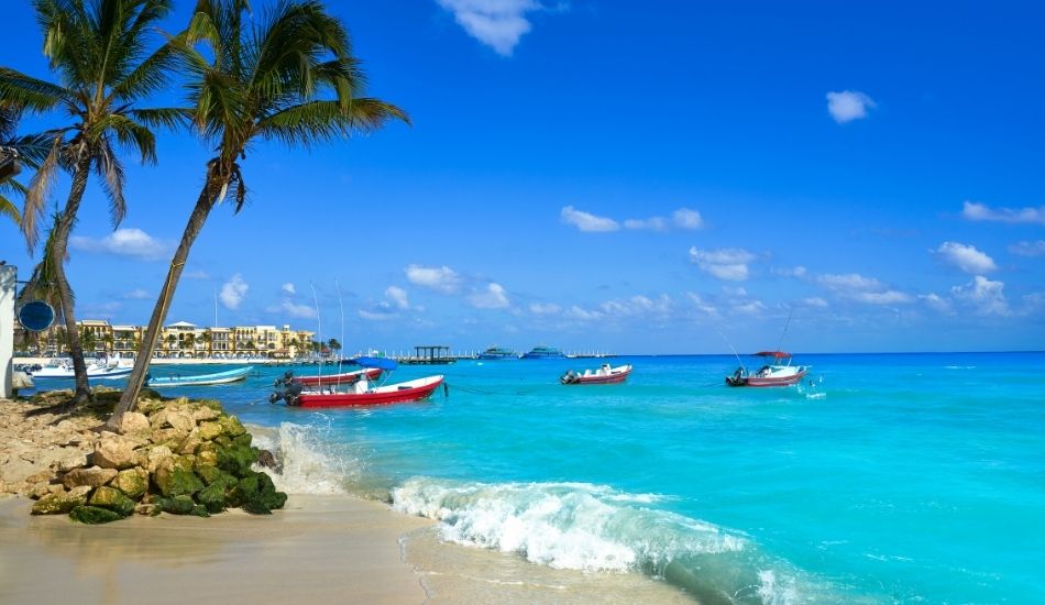 Boats on the turquoise waters of Playa del Carmen under a clear blue sky
